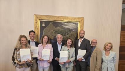 Costituita la rete d'impresa delle “Dimore Storiche della Contea di Gorizia” Otto persone in posa con cartelle davanti a una mappa del Comune di Gorizia.